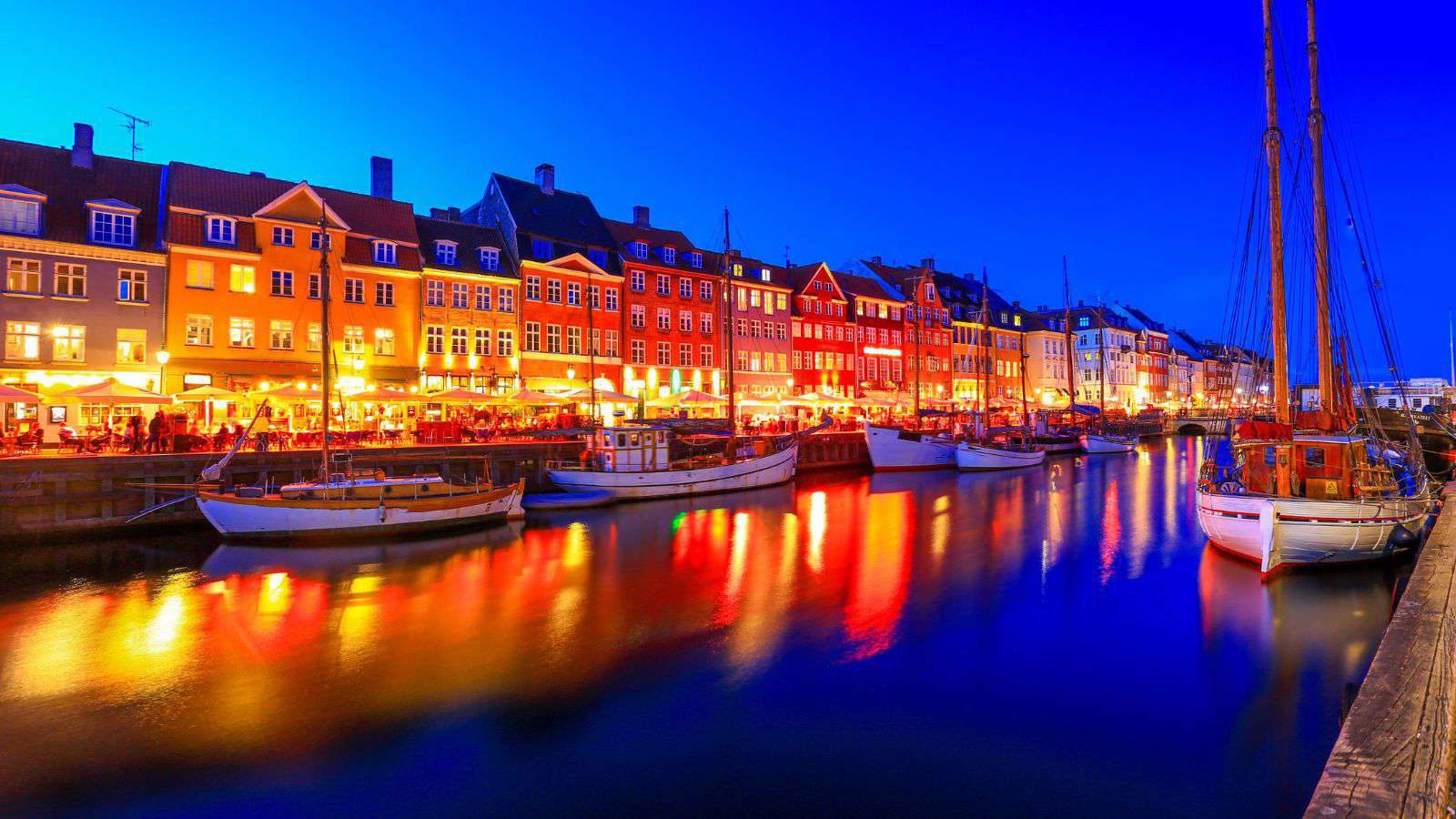 Warmly lit harbour cafés in Copenhagen at night